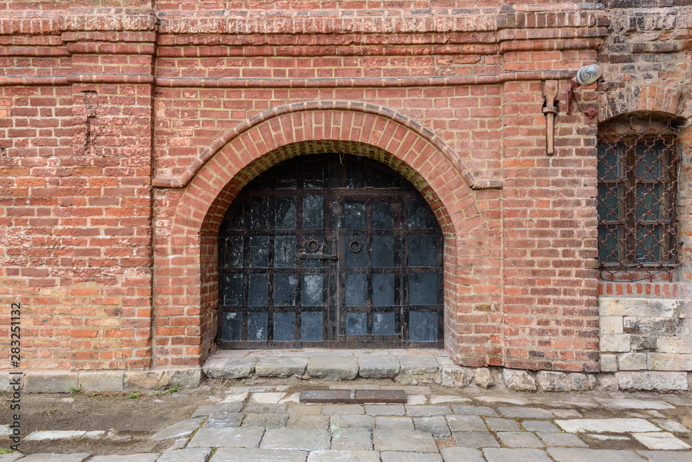 Antique iron gates in the old brick wall Antique iron gates in the old brick wall