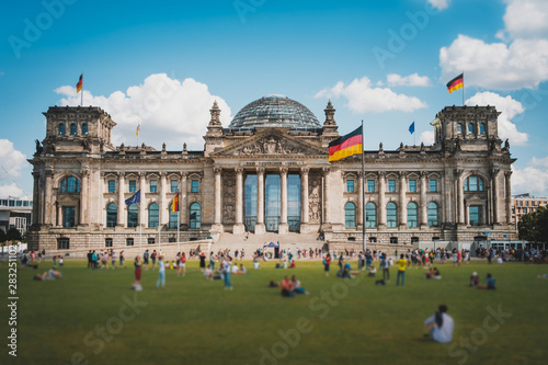 Many people on meadow in front of the Reichstag building (German Bundestag), a famous  landmark on a sunny, summer day photo