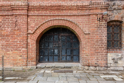 Antique iron gates in the old brick wall