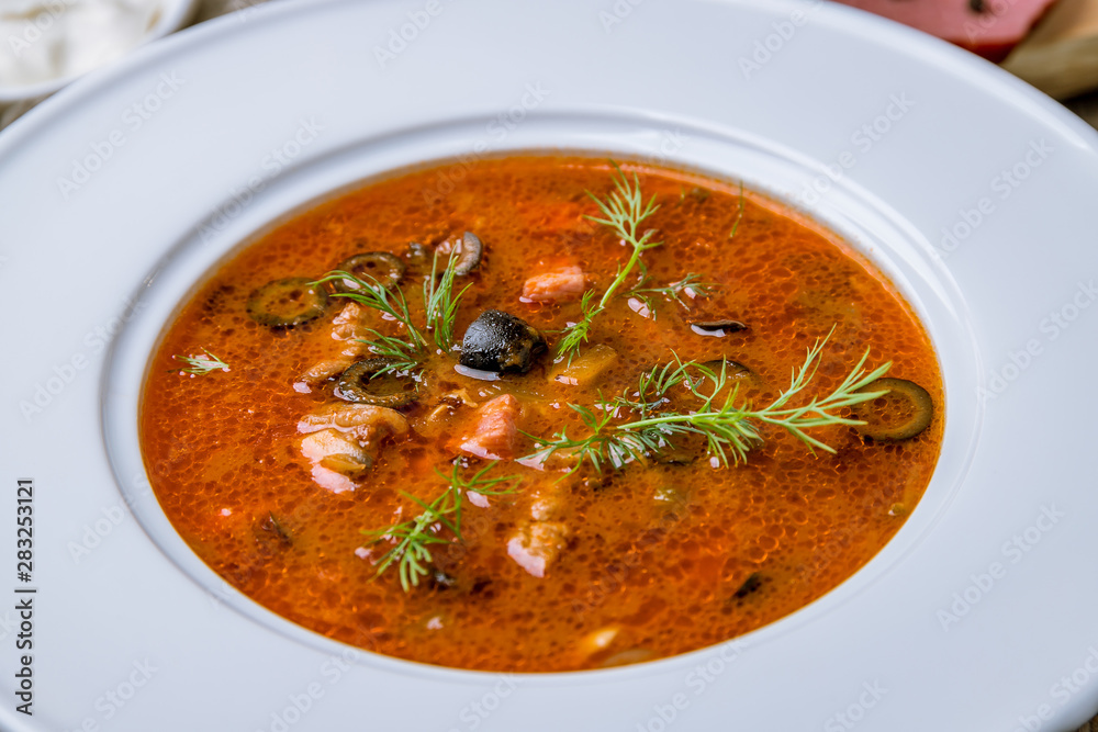 Meat Solyanka soup on wooden table Meat Solyanka soup on wooden table