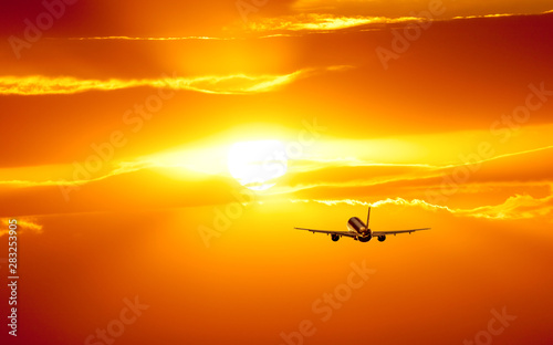 Plane is taking off at sunset
