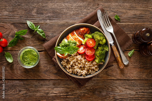 Billede på lærred Chicken lunch bowl with broccoli, fresh tomato, pearl barley porridge and basil