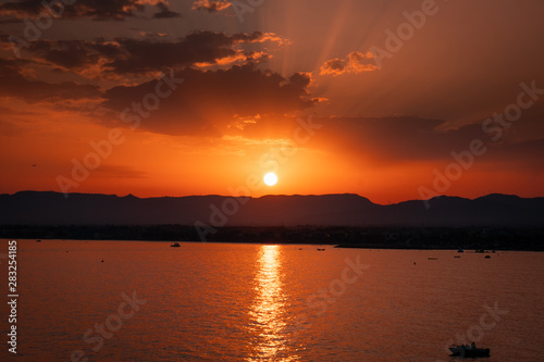 Sunset in Salou, Spain. It is a pleasant landscape where we see a sunset on the beach where the sun sets behind the mountain and the sea.