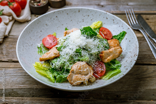 Salad caesar with chicken on old wooden table