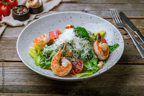 salad caesar with shrimps on old wooden table