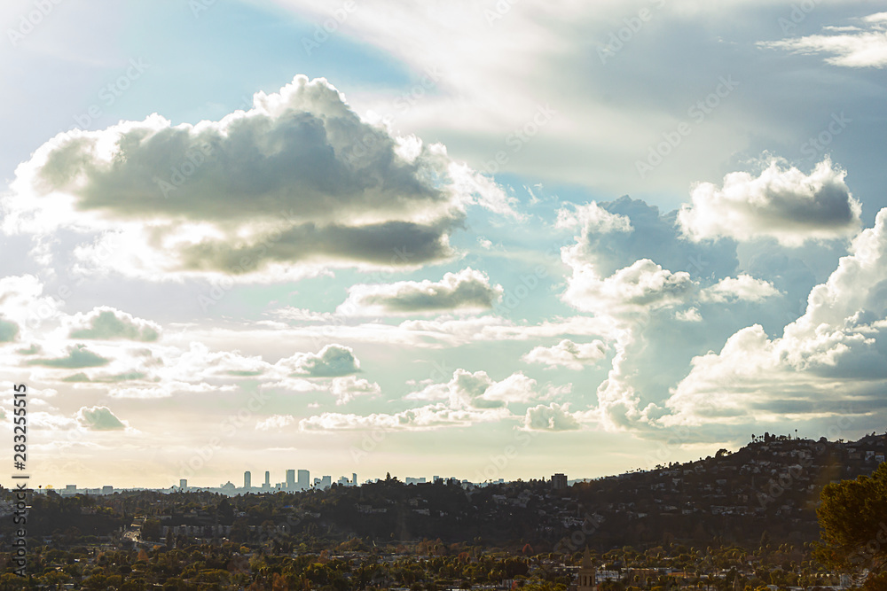 Obraz premium panaramic view of city businesses and homes with hillside homes and downtown LA towers in the distance