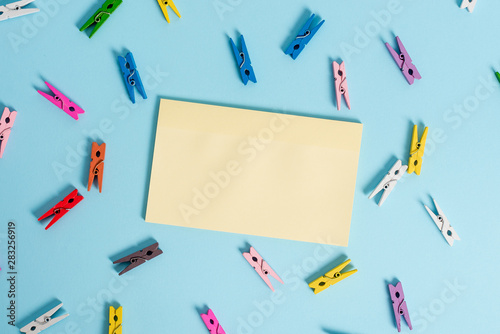 Colored clothespin rectangle shaped reminder paper light blue background