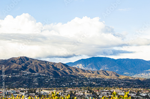 panaramic view of city businesses and homes with hillside homes and mountains