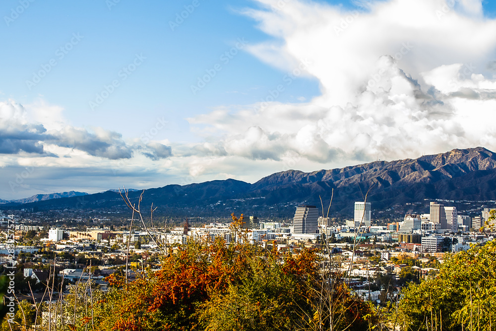 Obraz premium panaramic view of city businesses and homes with hillside homes and mountains