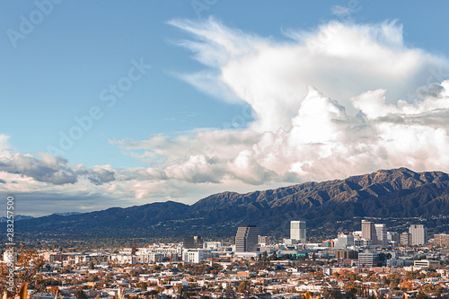 panaramic view of city businesses and homes with hillside homes and mountains