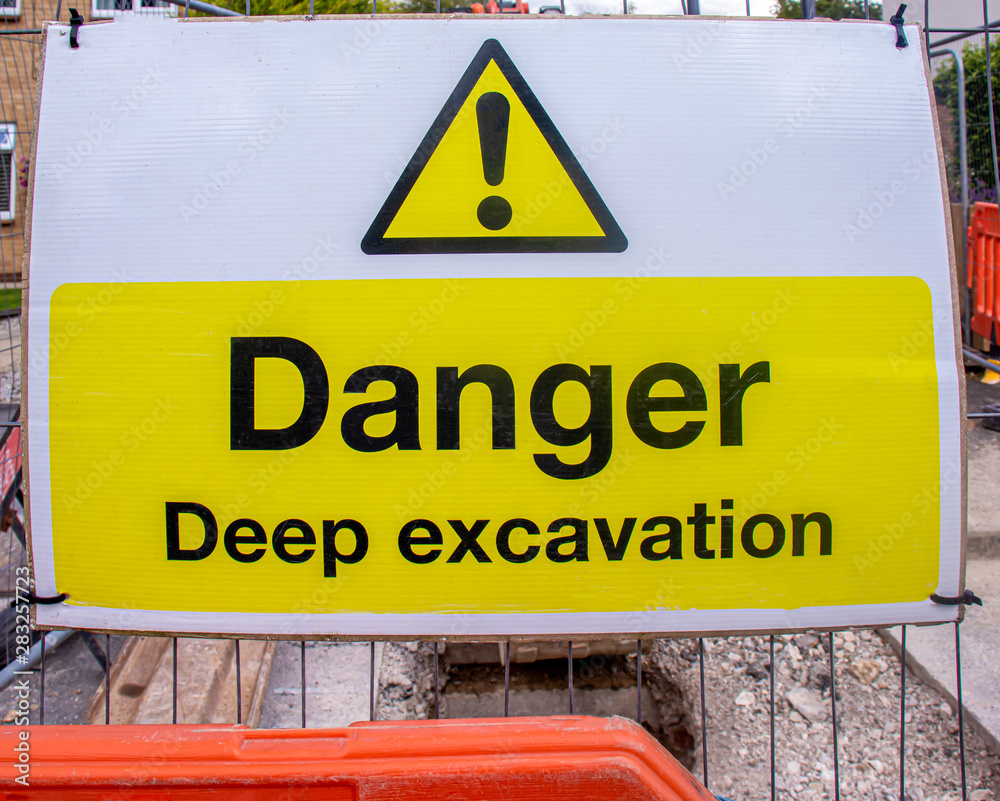 Hazard warning sign of a deep excavation Hazard warning sign of a deep excavation