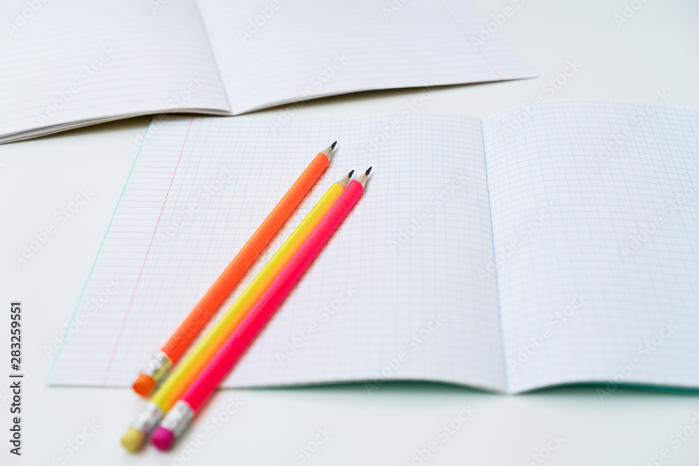 Blank notebook and pencils on white background. School supplies. White sketch book with colourful pencils. Note book and pencil Blank notebook and pencils on white background. School supplies. White sketch book with colourful pencils. Note book and pencil