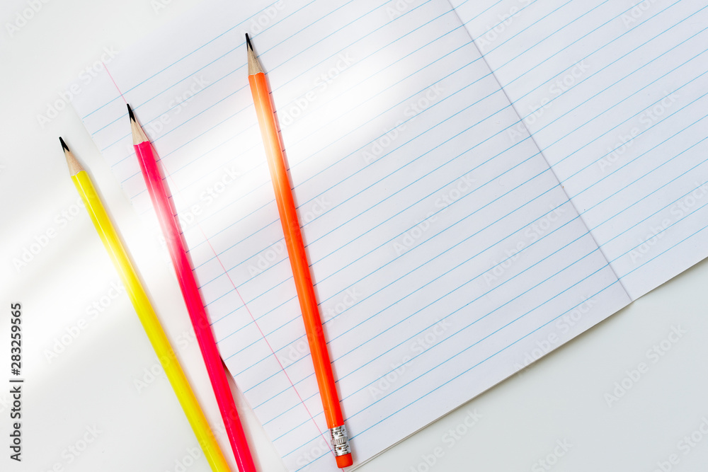 Blank notebook and pencils on white background. School supplies. White sketch  book with colourful pencils. Note book and pencil Stock Photo