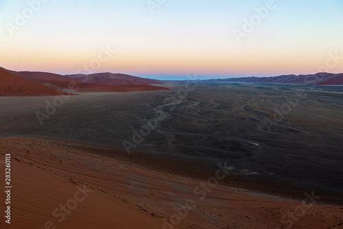 The rising sun illuminating the mighty dunes of the sossusvlei, as seen from dune 45, in Nambia. © Goldilock Project