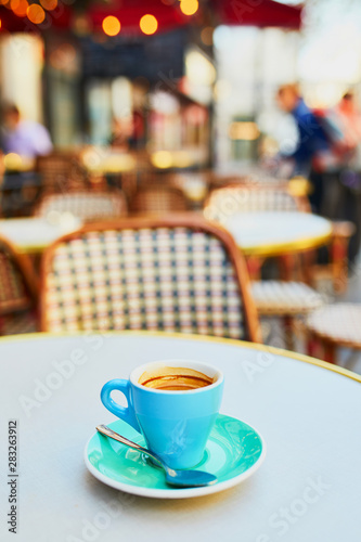 Cup of fresh hot espresso coffee on table of traditional Parisian outdoor cafe in Paris