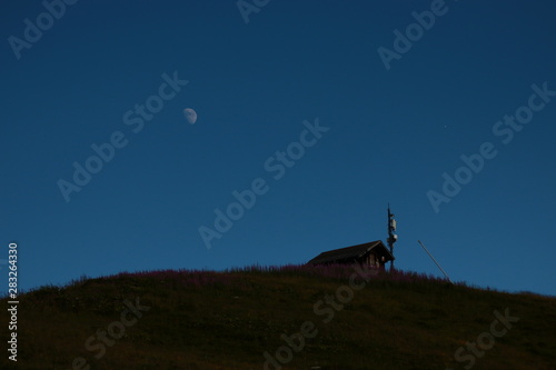 Moon Rising Over A Hut In The Mountains