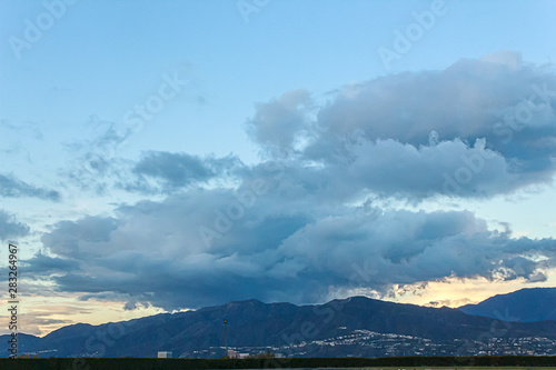 aerial view of san gabriel mountains with hillside residences and large storm clouds