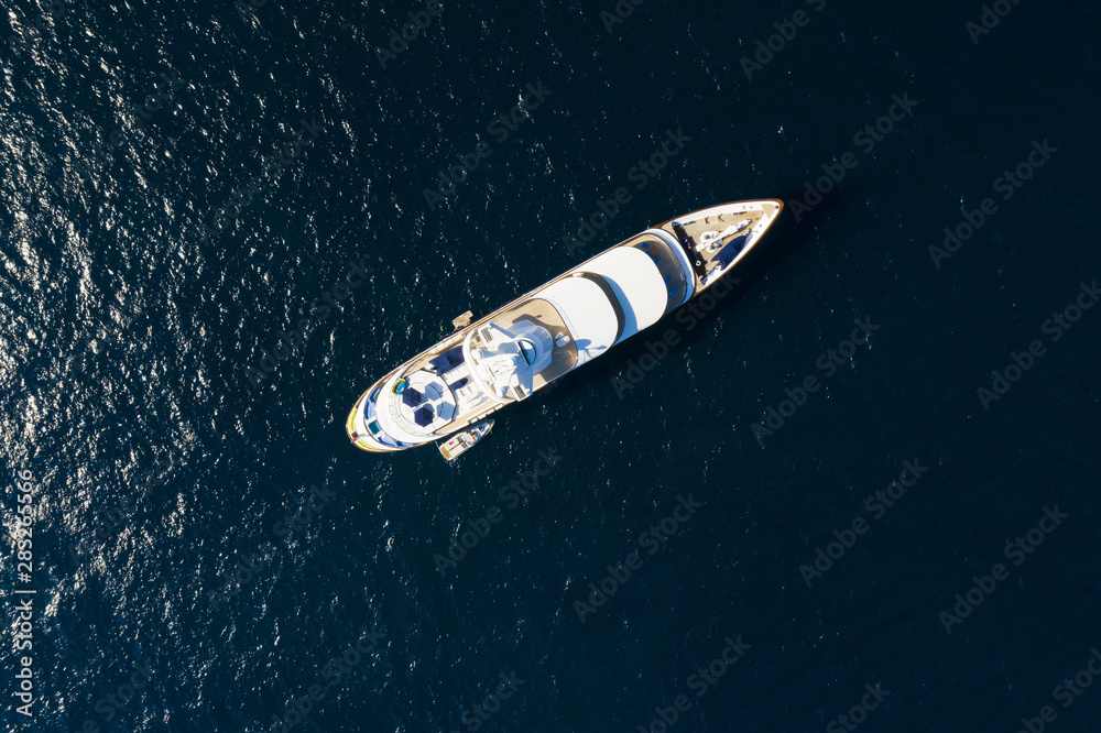 View from above, stunning aerial view of a luxury yacht sailing on a blue sea. Emerald Coast Sardinia, Italy. View from above, stunning aerial view of a luxury yacht sailing on a blue sea. Emerald Coast Sardinia, Italy.