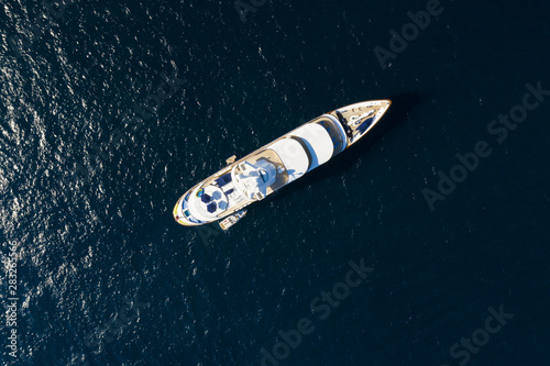 View from above, stunning aerial view of a luxury yacht sailing on a blue sea. Emerald Coast (Costa Smeralda) Sardinia, Italy. © Travel Wild