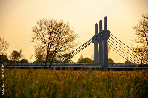 Pillars of the road bridge across the river Werre looking from the grass during the sunset photo