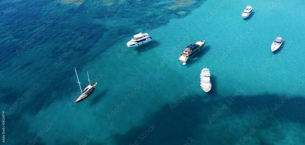 View from above, stunning aerial view of a beautiful bay with turquoise water full of boats and luxury yachts. Liscia Ruja, Emerald Coast Sardinia, Italy. View from above, stunning aerial view of a beautiful bay with turquoise water full of boats and luxury yachts. Liscia Ruja, Emerald Coast Sardinia, Italy.