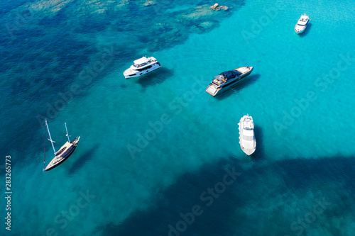 View from above, stunning aerial view of a beautiful bay with turquoise water full of boats and luxury yachts. Liscia Ruja, Emerald Coast (Costa Smeralda) Sardinia, Italy. © Travel Wild