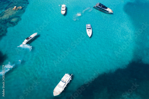 View from above, stunning aerial view of a beautiful bay with turquoise water full of boats and luxury yachts. Liscia Ruja, Emerald Coast (Costa Smeralda) Sardinia, Italy. © Travel Wild