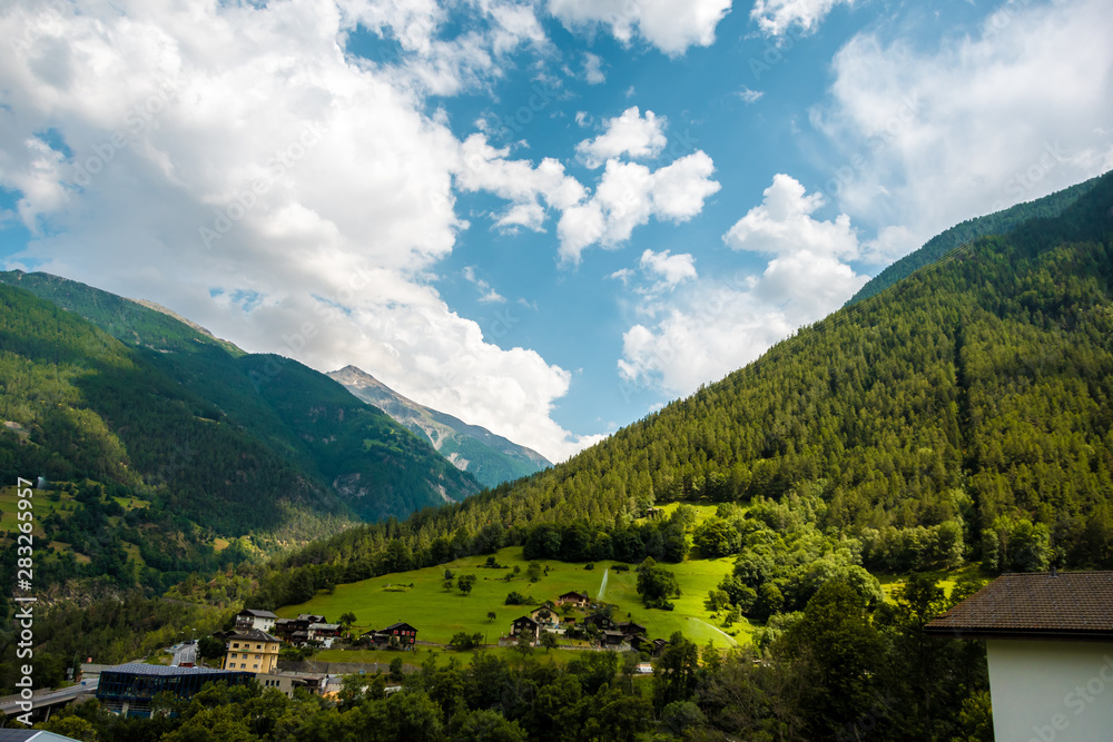 Amazing view of the hillside village and green slopes of the Swiss Alps. Colorful summer view of village. Idyllic outdoor scene in Switzerland, Europe