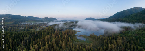 Aerial Panoramic View of Fairy Lake covered in clouds during a vibrant summer sunrise. Taken near Port Renfrew, Vancouver Island, British Columbia, Canada.