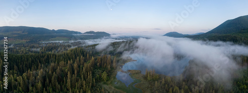 Aerial Panoramic View of Fairy Lake covered in clouds during a vibrant summer sunrise. Taken near Port Renfrew, Vancouver Island, British Columbia, Canada.