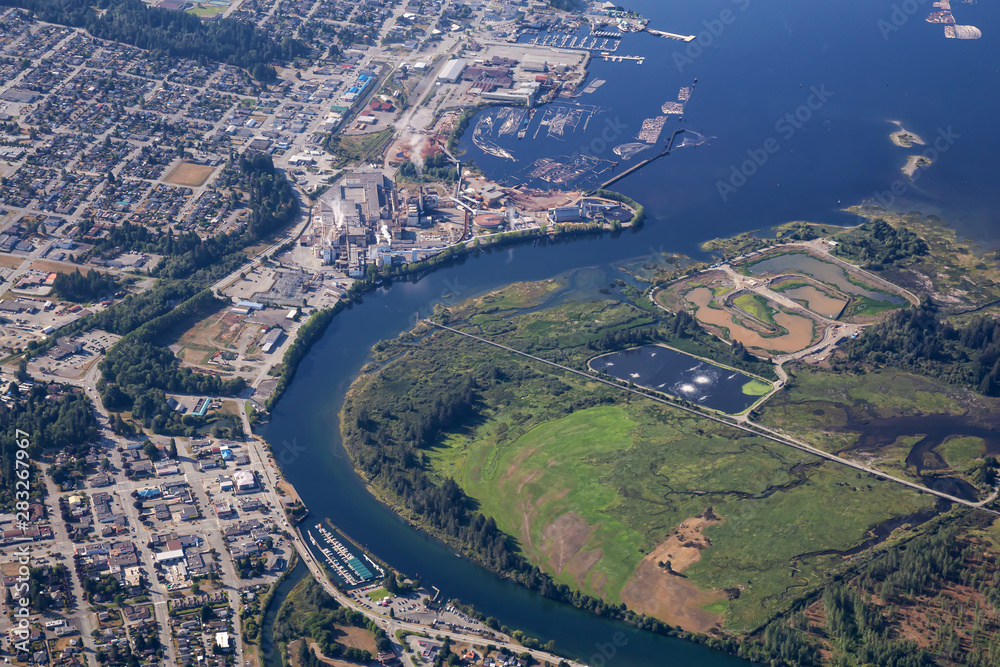 Aerial view of a small industrial town, Port Alberni, on Vancouver Island during a sunny summer morning. Located in British Columbia, Canada.