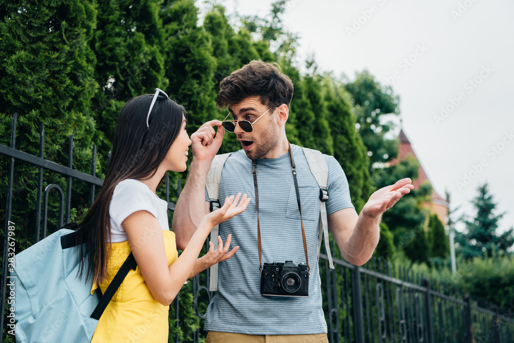 shocked man and asian woman talking and looking at each other shocked man and asian woman talking and looking at each other