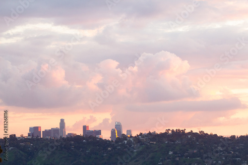 hillside view of homes with downtown towers under baby pink  lavender and blue sunset