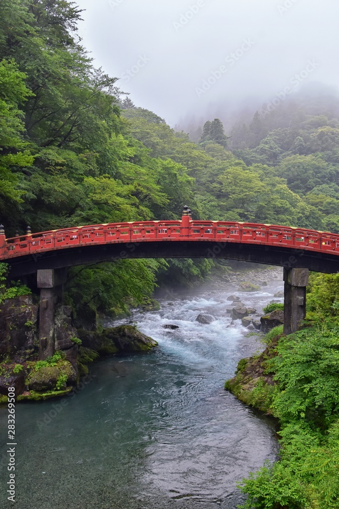 Shinkyo Bridge over the Daiwa River in Nikko outside of Tokyo, Japan in summer with cloud cover. Aisa. Shinkyo Bridge over the Daiwa River in Nikko outside of Tokyo, Japan in summer with cloud cover. Aisa.