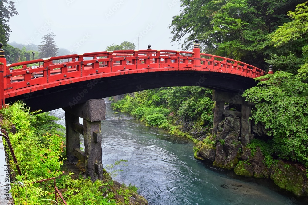 Shinkyo Bridge over the Daiwa River in Nikko outside of Tokyo, Japan in summer with cloud cover. Aisa. Shinkyo Bridge over the Daiwa River in Nikko outside of Tokyo, Japan in summer with cloud cover. Aisa.
