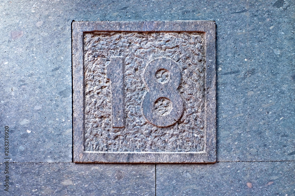 18, number eighteen, decorative numeral on gray surface. 18, number eighteen, decorative numeral on gray surface.