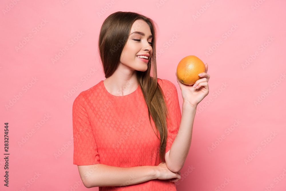 attractive smiling young woman holding grapefruit on pink attractive smiling young woman holding grapefruit on pink