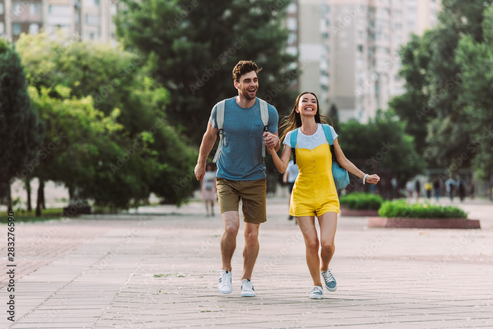 handsome man and asian woman running and looking away