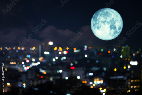 super super full harvest moon on night sky and reflection light of city on window
