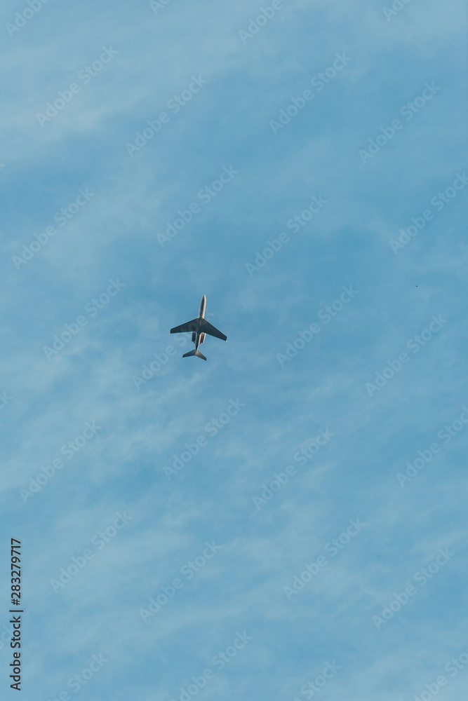 bottom view of airplane flying in blue sky bottom view of airplane flying in blue sky