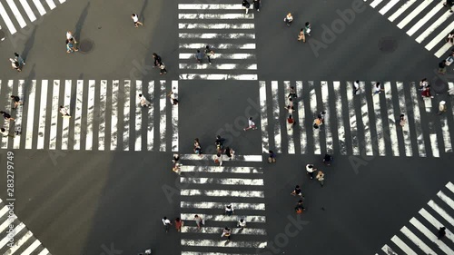 4K High Angle aerial view wide shot of pedestrian man and woman tourist walking crossing the street crosswalk downtown district intersection road in summer at Ginza, Tokyo, Japan