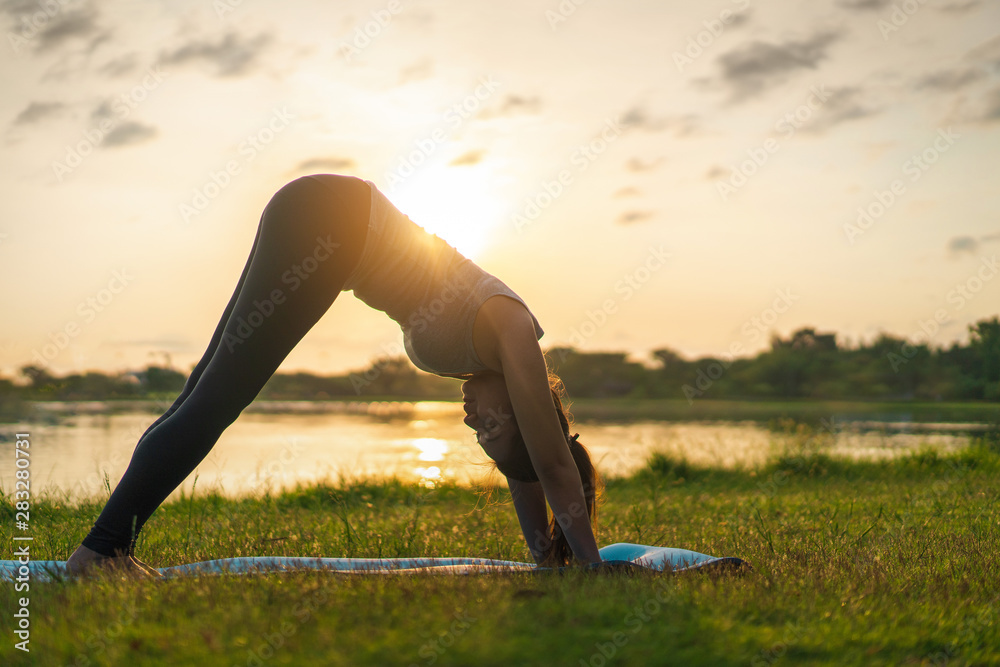 Fototapeta premium Young asian woman wearing exercise suit and stretching before play yoga on fitness mat in park, Healthy concept, Mind-body improvements concept.;