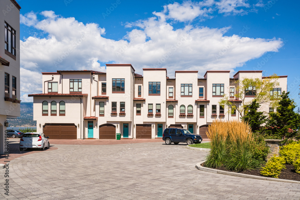 Townhomes with wide garage door and cars parked in front