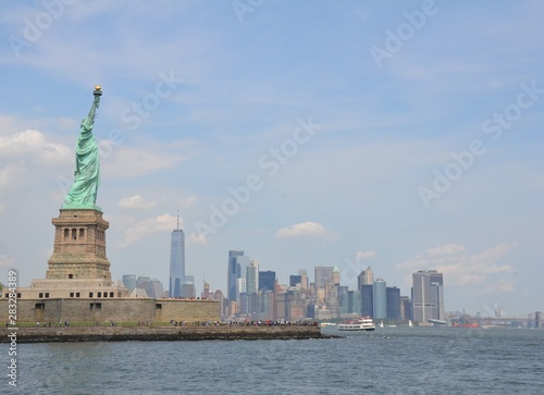 statue of liberty in New York with water and ferries © Justin