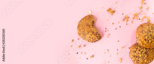 Galletas integrales de avena y semillas de ajonjoli sobre un fondo rosado photo