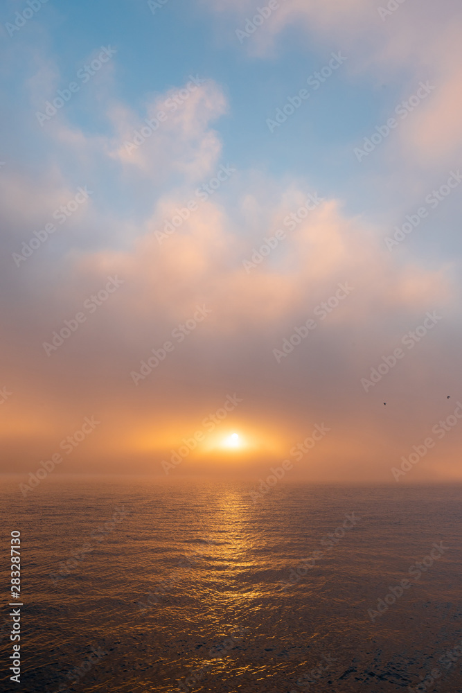 Foggy sunrise view over the water.