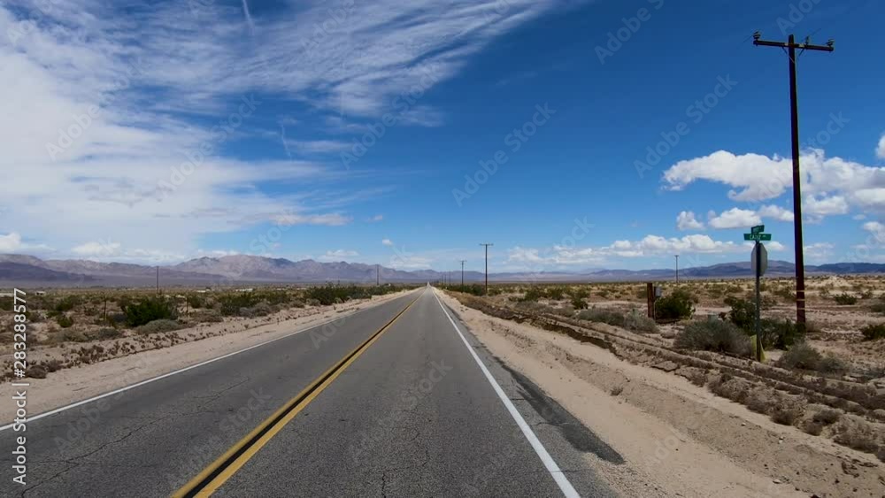 Driving down the endless desert road. Point of view shot driving on long straight road in desert. Adventure travel in a desert. California. USA Driving down the endless desert road. Point of view shot driving on long straight road in desert. Adventure travel in a desert. California. USA