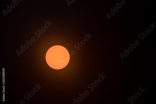 a shot of the sun in the sky through the dark filter