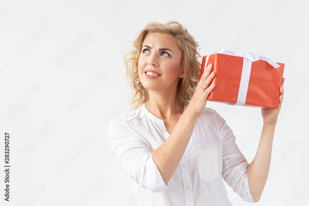 Holidays concept - Portrait of a smiling cute woman opening gift box isolated on a white background with copy space Holidays concept - Portrait of a smiling cute woman opening gift box isolated on a white background with copy space