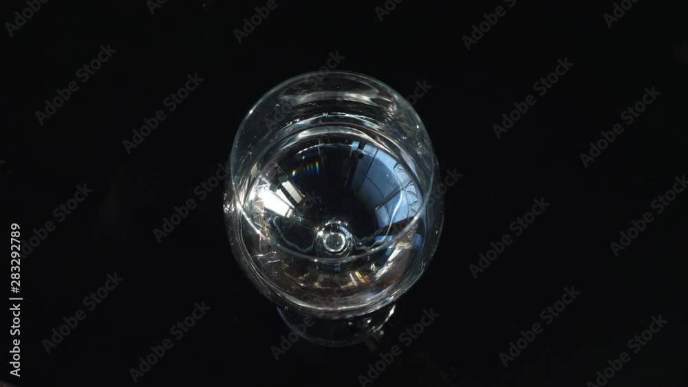 Top view of ripple effect in a transparent glass of water . water droplets falling into glass in a close up view . Top view of ripple effect in a transparent glass of water . water droplets falling into glass in a close up view .